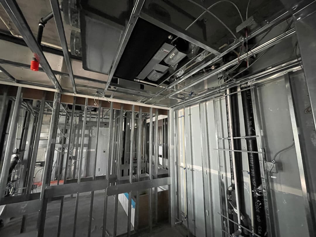 Interior shot of a partially constructed building with exposed framing and ductwork.